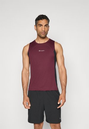 Débardeur de sport bordeaux avec des panneaux latéraux noirs, en tissu texturé, et un logo sur la poitrine. Porté avec un short noir.