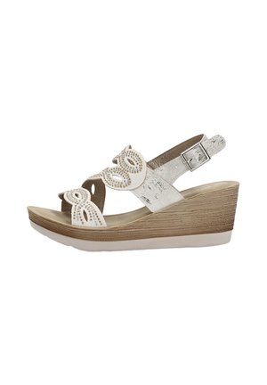 Sandali con zeppa con una tomaia beige caratterizzata da decorative aperture e strass, cinturino alla caviglia regolabile e una base piattaforma marrone texturizzata.