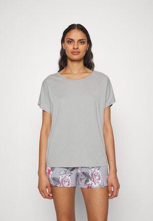 Lichtgrijs katoenen T-shirt met een ronde hals en korte mouwen, gecombineerd met shorts met bloemenprint in zachte pastelkleuren.