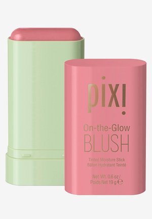 Tonal fugtig blush i pink med guldtekst, opbevaret i en cylindrisk pink beholder, ved siden af en grøn drej-op base.
