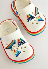 Baltas gumijas kluči ar varavīksnes krāsas zoli. Uz tiem ir krāsainas, trīsdimensiju rotājumi: skeitbords, burāšanas laiva un teksts "SUPER STAR".