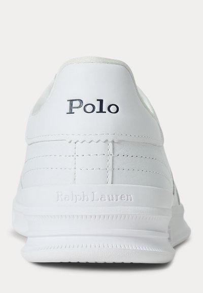 Witte sneaker van achteren gezien met "Polo" in zwart gedrukt en "Ralph Lauren" in reliëf op de zool.