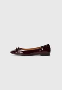 Ballerines en cuir verni bourgogne avec un bout pointu, accent de nœud décoratif à l'avant et un petit talon fin. Texture lisse.