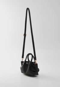 Borsa a mano in pelle nera con texture granulosa, doppi manici superiori e tracolla removibile. Presenta accessori in tonalità oro e un design strutturato.
