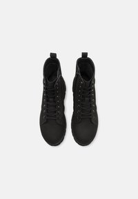 Bottes noires à mi-mollet avec une texture lisse et mate, dotées d'un laçage, d'une fermeture éclair sur le côté et d'un design à bout rond.