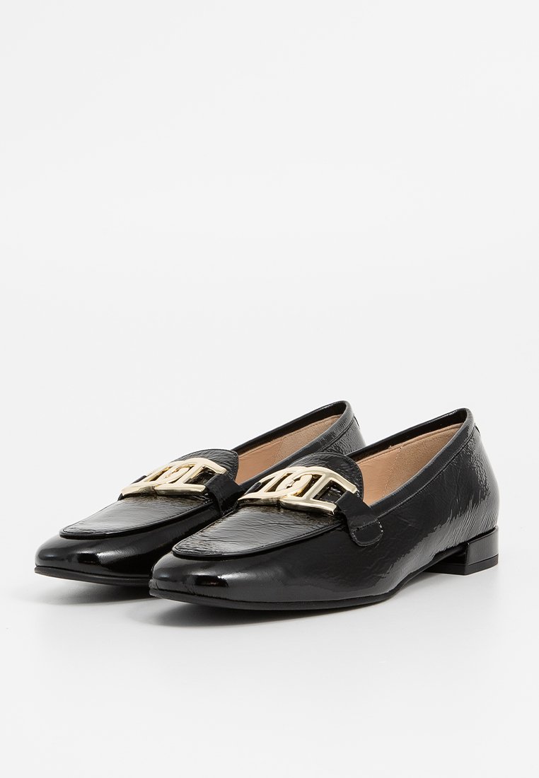 Svarta läderloafers med en glänsande yta, platt häl och en framträdande guldtonad spänne på framfoten. Snygg design och klassisk form.