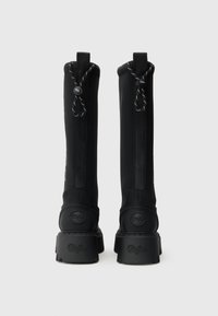 Juodos kelių ilgio batai su lygia, matinėmis apdailomis; turi išryškintus logotipo akcentus ir tekstūruotus padus; viršuje su raišteliais.