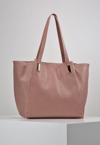 Borsa tote in pelle rosa con una texture morbida, forma rettangolare e due lunghe maniglie. Presenta dettagli in metallo dorato.