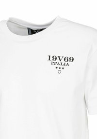 Witte katoenen t-shirt met een zwarte bedrukte afbeelding van "19V69 ITALIA" en drie sterren. Ronde halslijn en korte mouwen.