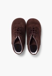 Zapatos de ante marrón con cordones, de textura suave, puntera redonda, detalles perforados y forro interior blanco en contraste.