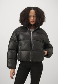Svart pufferjakke i syntetisk materiale, kort design, glidelås, oversized passform, med quiltede seksjoner og høy krage.