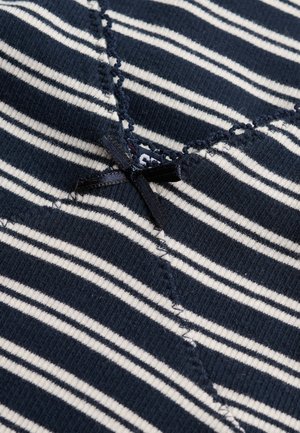 Tessuto a righe blu navy e bianco con un piccolo fiocco nero cucito e dettaglio di bordo smerlato su materiale lavorato a maglia strutturato.