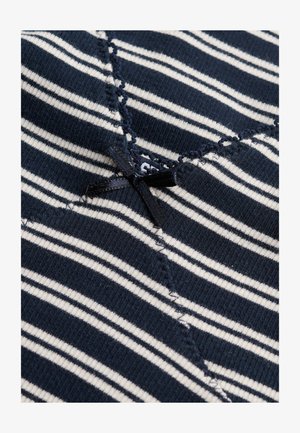 Tessuto a righe blu navy e bianco con un piccolo fiocco nero cucito e dettaglio di bordo smerlato su materiale lavorato a maglia strutturato.