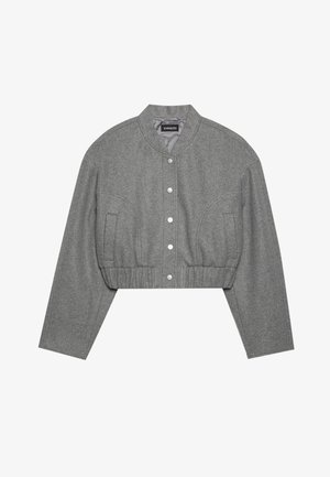 Cropped gray jacket with a round collar, snap button front, and elasticated waist. Features two side pockets and a textured fabric.