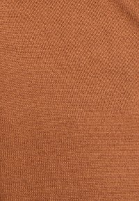Tejido de punto en un cálido tono naranja terracota. Presenta una textura fina con un patrón uniforme de puntadas estrechas.