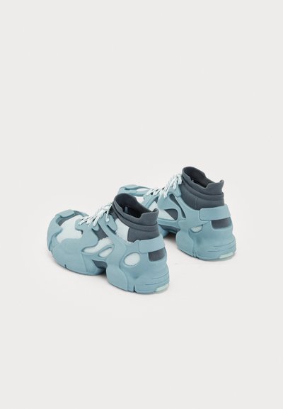 A pair of sneakers featuring a light blue upper with dark blue accents, mesh panels, and a chunky sole; textured with cut-out designs.