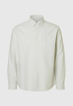 Hele roheline ja valge triibuline nööbiga särk, millel on krae, pikad varrukad ja rinnatasku. Omab ümarad plastnööpe.