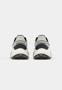 Αθλητικά παπούτσια με γκρι και μαύρο επάνω μέρος, επενδυμένο κολάρο και χοντρή λευκή σόλα. Διαθέτουν ανάγλυφο σχέδιο στη φτέρνα.