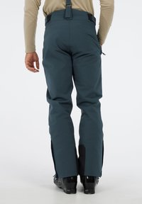 Blauwe skibroek met verstelbare schouderbanden, een slank ontwerp, ritsventilatie aan de zijkanten en versterkte zwarte accenten bij de enkels.