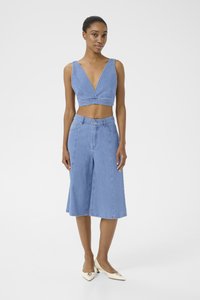 Lys blå denim crop topp med dyp V-hals og matchende høy midje culotte. Jevn tekstur, minimal søm og avslappet passform.