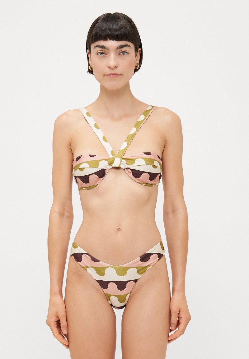 Completo bikini con parte superiore annodata e decorata con forme ondulate in rosa, verde e marrone. La parte inferiore ha un taglio basso a forma di V.