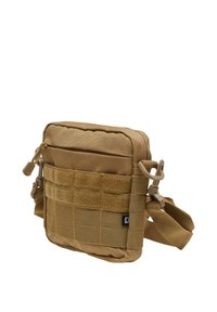 Tan crossbody bag with a padded design, front zip pocket, Velcro panel, and adjustable strap. Made of durable fabric with grid texture.