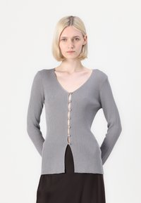 Gray ribbed long-sleeve cardigan with a deep V-neck, featuring a row of buttons down the front and a side slit at the hem.