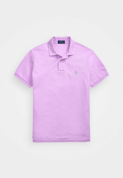 Lilla lühikeste varrukate polo särk, mis on valmistatud puuvillast. Särgil on krae, kaks nuppu ja väike roheline logo vasakul rinnal.