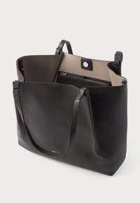 Sac tote en cuir marron avec un extérieur texturé, deux poignées et un intérieur clair comportant un compartiment zippé et une fermeture à bouton.