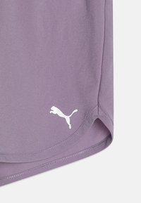 Pantalones cortos deportivos de color morado claro con una textura suave, que presentan un logo blanco de Puma. El dobladillo es redondeado y cuenta con detalles de costura reforzada.