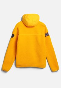 Yellow fleece jacket with a hood, featuring a textured surface, long sleeves, and a decorative patch with a Norwegian flag on the sleeve.