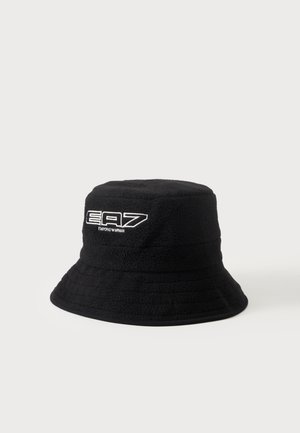 Chapeau bob texturé noir avec le logo blanc EA7 Emporio Armani brodé à l'avant, sur un fond clair uni.