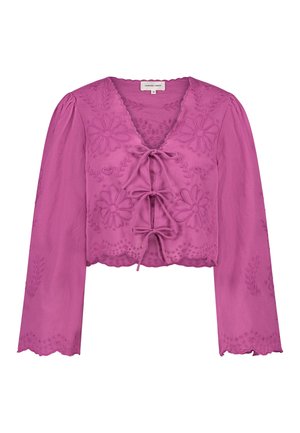 Fuchsia cropped blouse with long sleeves, featuring floral embroidery, a deep V-neck, and a tie front. Scalloped hem and sleeve edges.
