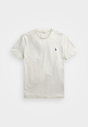 T-shirt cinza claro de manga curta em um tecido suave. Possui um logo sutil em azul no lado esquerdo do peito. Design clássico de gola redonda.