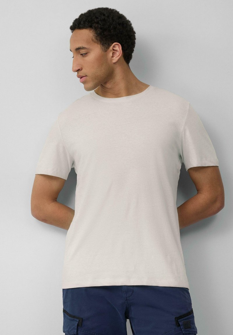 Lichtgrijze t-shirt met korte mouwen en een ronde hals. Zachte stof, eenvoudig ontwerp en reguliere pasvorm. Geen patronen of extra details.