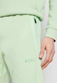 BOSS HEADLO - Spodnji deli trenirk - open green