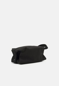 Bolso de cosméticos de tela negra con cierre de cremallera y asa lateral. El diseño es rectangular con una textura suave y un estilo minimalista.