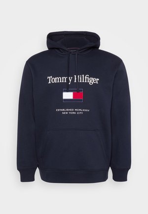 Granatowy hoodies wykonany z mieszanki bawełny. Posiada przednią kieszeń, kaptur ze sznurkiem oraz haftowane logo z prostokątnym trójkolorowym wzorem.