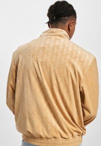 Karl Kani CHEST SIGNATURE MONOGRAM VELVET - Sportinė striukė - sand