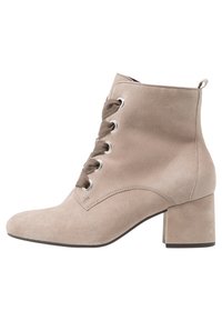 Botín de ante color beige con punta redonda, diseño con cordones en la parte delantera, ojetes de metal y tacón cuadrado. Textura suave y construcción resistente.