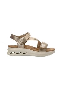 Sandalias para mujer en tono dorado con correas elásticas, plantilla acolchada y una suela media blanca con recortes ovalados para mayor transpirabilidad.