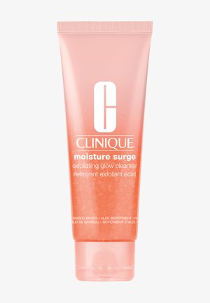 Tubka żelu złuszczającego i rozświetlającego Clinique Moisture Surge w kolorze brzoskwiniowym z widocznymi małymi kuleczkami i białym tekstem z przodu.