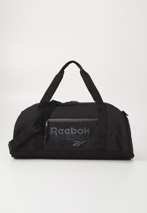 Mala de viagem preta feita de tecido durável, com um grande compartimento principal, alça de ombro ajustável e bolso frontal com fecho e marca Reebok.