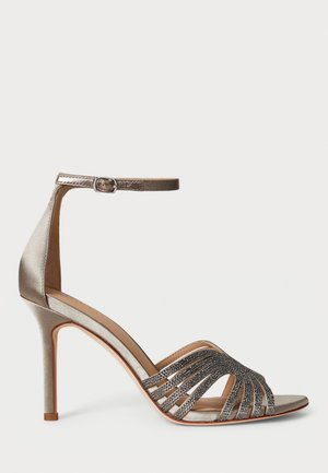 Sandal de salto alto em satin prateado com tiras no tornozelo, design recortado, decorado com detalhes cintilantes na área dos dedos, e um salto agulha.