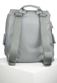 Sac à dos en cuir gris avec surface texturée, équipé de bretelles ajustables, de poches latérales et de détails en métal.