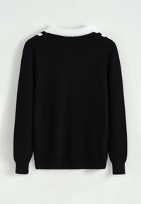 Pull noir à manches longues avec col blanc et accents d'épaule, vu de dos sur un fond clair uni.