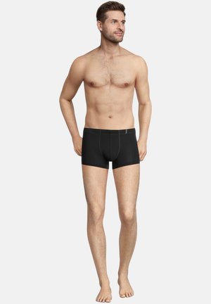Schwarze Boxer-Briefs mit Kontraststichen, elastischem Bund und körperbetontem Design. Das Material ist glatt mit einem leichten Glanz.