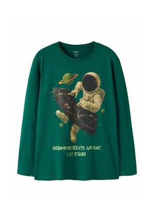 Chemise verte à manches longues avec un graphisme d'un DJ astronaute avec des planètes et le texte "Dropping beats among the stars" sur le devant.