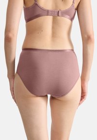 High-waisted, pink underwear made of soft textured fabric, featuring a smooth waistband and seamless edges for comfort.