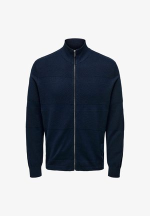 Pulover tricotat cu fermoar, de culoare bleumarin, cu guler înalt; prezintă dungi orizontale texturate și manșete cu nervuri la mâneci și la tiv.